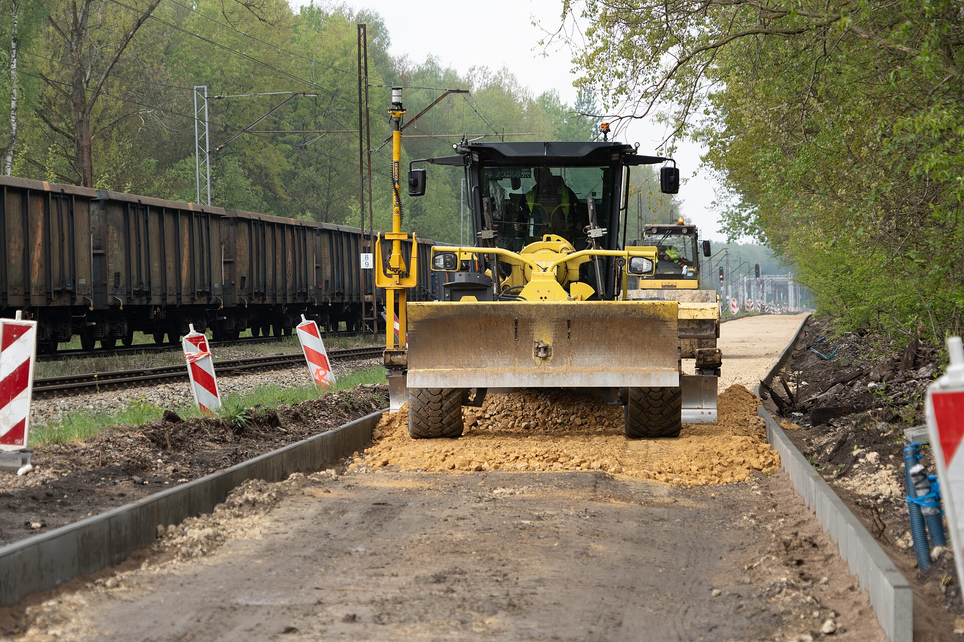 Niveleuse en train d'uniformiser la surface traitee avant la compaction.
